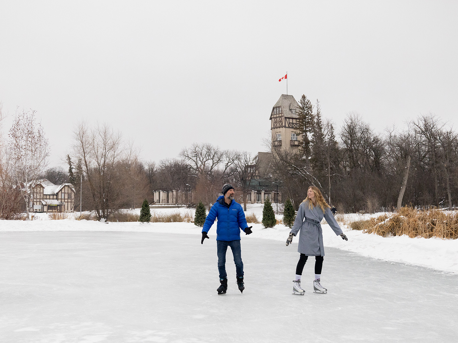 a man and woman skate on the duck pond at Assiniboine Park